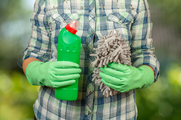 Woman with the bottle of washing liquid and the rag.