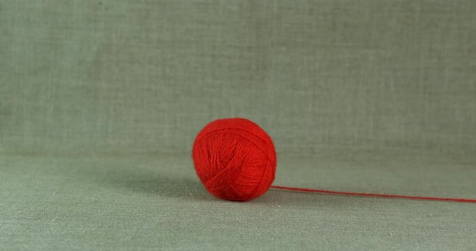 Wool ball on the floor. A view of woolen red yarn ball lay on the floor in the room.