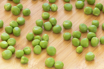 Closeup shot of fresh green peas on a brown surface