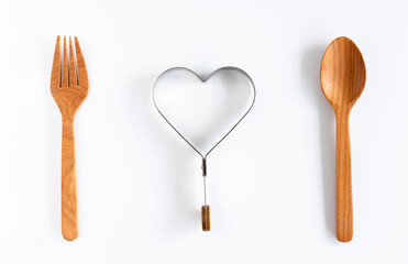 A heart health concept - heart plate, knife, spoon and fork isolated on white background.