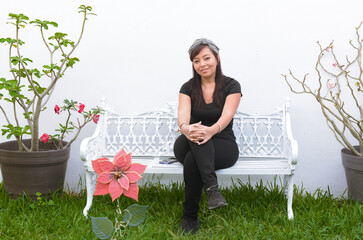 Portrait of a Mexican  woman sitting on a bench.