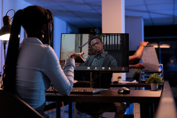 African american woman meeting with man on remote teleconference, using online internet call to chat with manager. Talking on videoconference telework, webcam telecommunications at night.