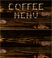 A menu of coffee drinks made from coffee beans on the background of a burnt board