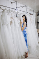 Woman choosing wedding dress in shop