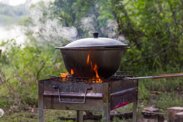 cook food in a cauldron in nature, a boiling cauldron on the grill, cooking on a fire, food in nature