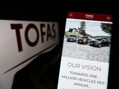 Stuttgart, Germany - 06-11-2022: Person holding cellphone with webpage of car manufacturer Tuerk Otomobil Fabrikasi (Tofas) on screen with logo. Focus on center of phone display.