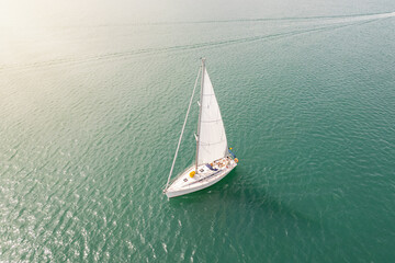 Fototapeta premium Aerial view of sailing yacht with white sail