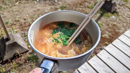 Eating pho(Vietnamese rice noodles) in a cooking pan at porch