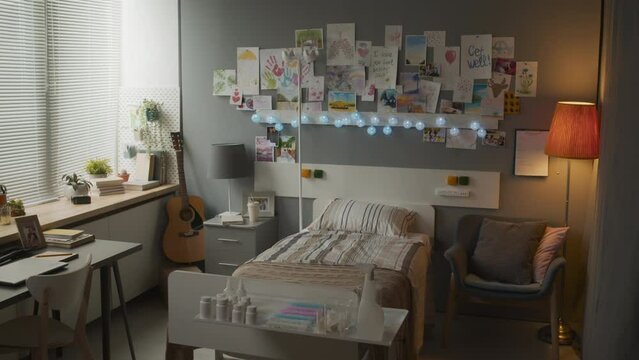 View of decorated hospital ward of child or teenager with garland, guitar, many pictures, drawings and get well soon postcards on wall daytime