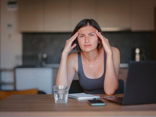 Frustrated sad woman feeling tired, worried about problem sitting at laptop, depressed girl worried about reading bad news online, debt notification email or negative message