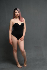 Full length photo in black bodysuit caucasian woman standing straight and looking at camera