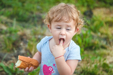 A child eats bread in the park. Selective focus.