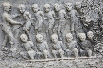 Memorial shrine festooned with bas-reliefs of Khmer Rouge atrocities at Wat Somrong Knong. Cambodia.  18.04.2019