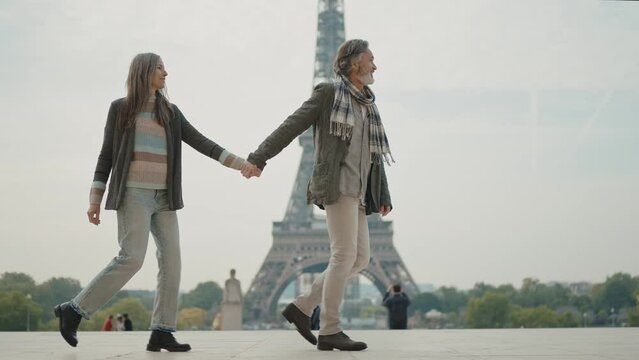 Happy senior couple in Paris. Senior woman and man spending time together at the eiffel tower. Concept about european tourism and landmarks	