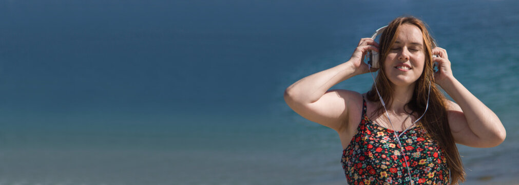 Relaxed Curvy Woman On The Beach With Headphones And Copy Space