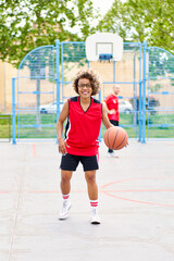 Fototapeta premium girl with afro hairstyle with a ball on a basketball court