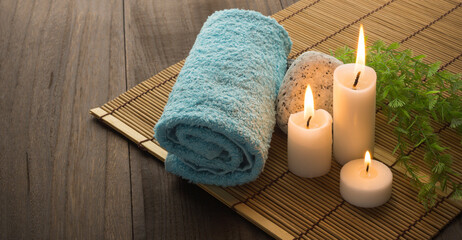 Obraz na płótnie Canvas towel, lit candles, stone and plant on a wooden base. relaxed atmosphere. spa.