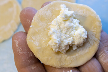 preparation of dumplings with cottage cheese. a piece of dough with a filling on the hand