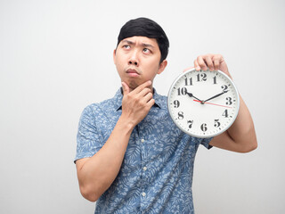 Young man feel confused thinking something holding analog clock am isolated
