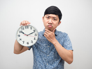 Man blue shirt serious thinking and confused holding analog clock am isolated