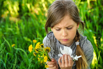 Portrait of little sad girl with allergy symptoms in nature