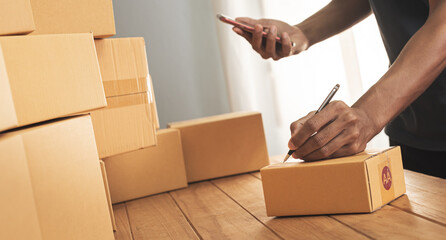 Shipment Online Sales .Man worker delivery service and working packing box, business owner working checking order to confirm before sending customer in post. Online selling, e-commerce Start up.