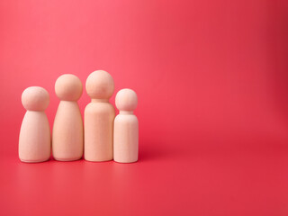 Wooden figures on a red background with copy space. Concept of family.