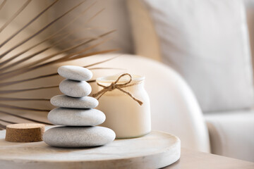 Obraz na płótnie Canvas Sea stones balance and candle on wooden table, spa and relax concept, space for text, selective focus horizontal banner