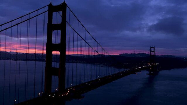Cars crossing Golden Gate Bridge at dawn in San Francisco.
