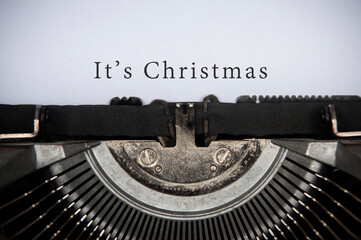 Fototapeta na wymiar It is Christmas text typed on an old vintage typewriter.
