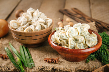 Fototapeta na wymiar Closeup on bowls of cooked russian dumplings pelmeni