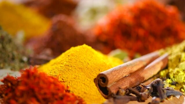 Spices. Various Indian Spices on wooden table. Spice and herbs rotating on wood background. Assortment of Seasonings, condiments. Cooking ingredients, flavor. Slow motion 4K UHD video. 