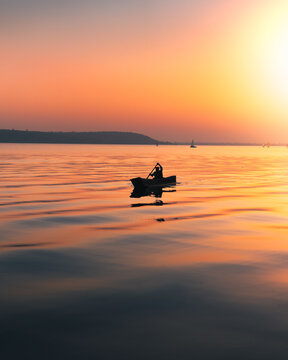 Silhouette of a person in a boat at sunset
