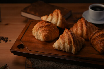 Tasty croissants on wooden cutting board ready to serve for breakfast. Breakfast, bread bakery products cafe concept