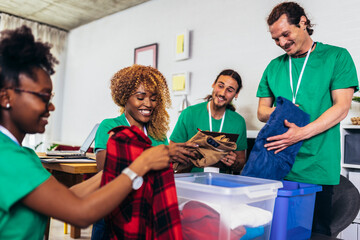 Obraz premium Volunteers putting clothes in donation boxes, social worker making notes charity