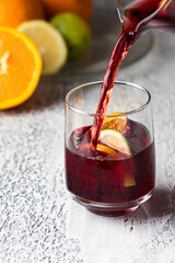 Refresh Sangria drink pouring into the glass with citrus fruit. Spanish beverage concept.