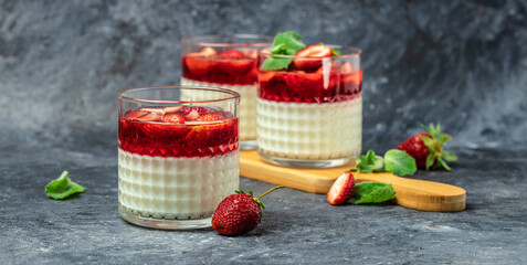Italian dessert Panna Cotta with jelly strawberries and mint. Long banner format