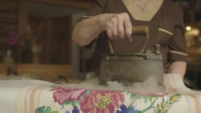 Grandmother ironing retro tablecloth, Ukrainian housewife