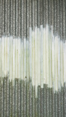 Tachadura de pintura blanca en metal corrugado