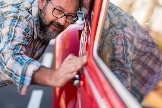 Close up of man having car of his new car. Vehicle lovers concept with male people checking shiny and polish - owner or mechanic with automobile . Transportation concept and dreaming adult