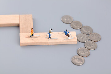 Miniature scene the direction of money leads skiers forward