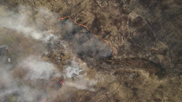 Aerial top-down orbit over the wildfire in the suburban area - natural disaster due to the drought