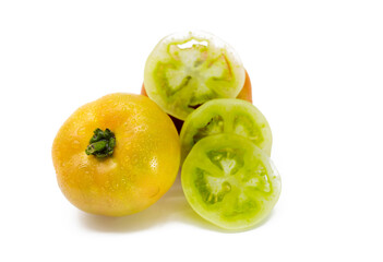 half ripe tomato with slices on white background