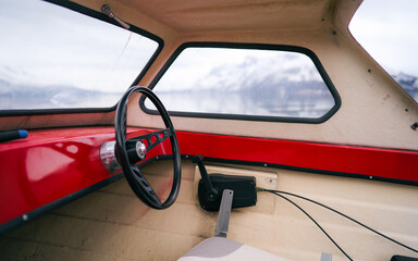 Pleasure motor boat moored in the harbor. Views of the Lyngen Alps already snowy. Closeup. Troms og Finnmark, Norway