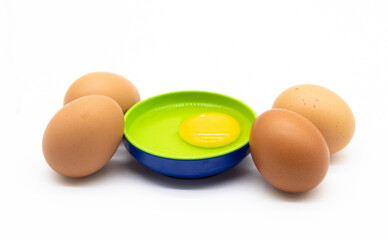 whole eggs and broken in a plate isolated on white background,