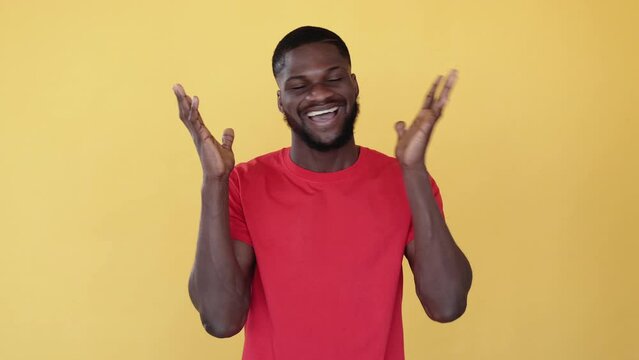 Excited african man. Victory celebration. Positive surprise. Boomerang animation. Success joy. Happy amused satisfied black guy raising hands gif loop isolated on orange free space.