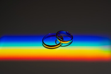 Rainbow beam on wedding rings. lgbt flag. 