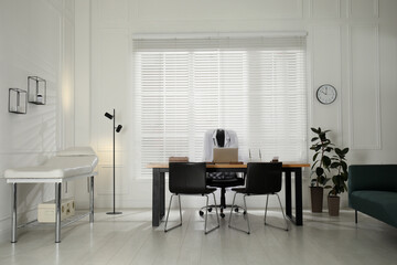Modern medical office interior with doctor's workplace and examination table
