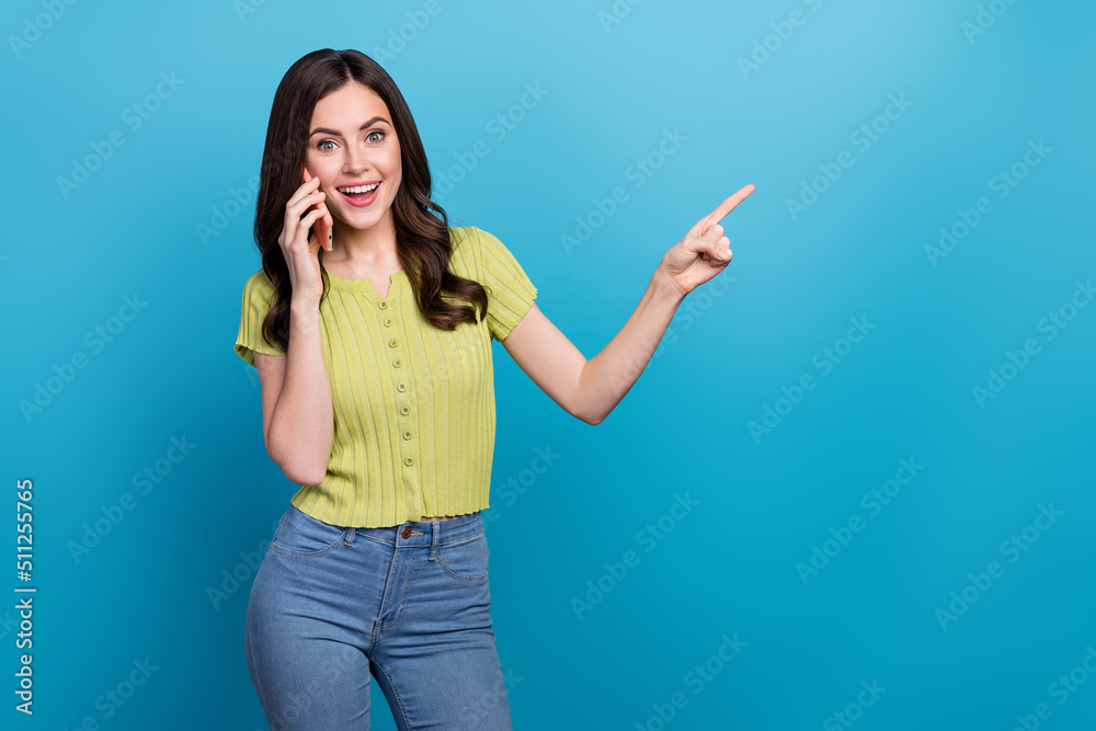 Sticker Photo of cute young brunette wavy hairstyle lady talk telephone index promo wear green top isolated on blue color background