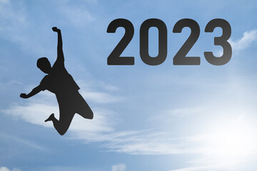 Fototapeta na wymiar Concept Happy new year 2023 Silhouette image of happy man jump on blue sky background.